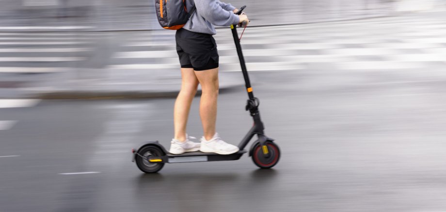 motion blur picture of a person with an electric scooter on a city street