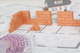 Model house construction with brick on blueprint and five hundred euro banknote