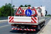 A worker's truck with roadsigns at a road construction site