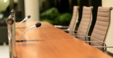 Isolated view of a microphone in the front of a conference room among blurred other mikes in the background