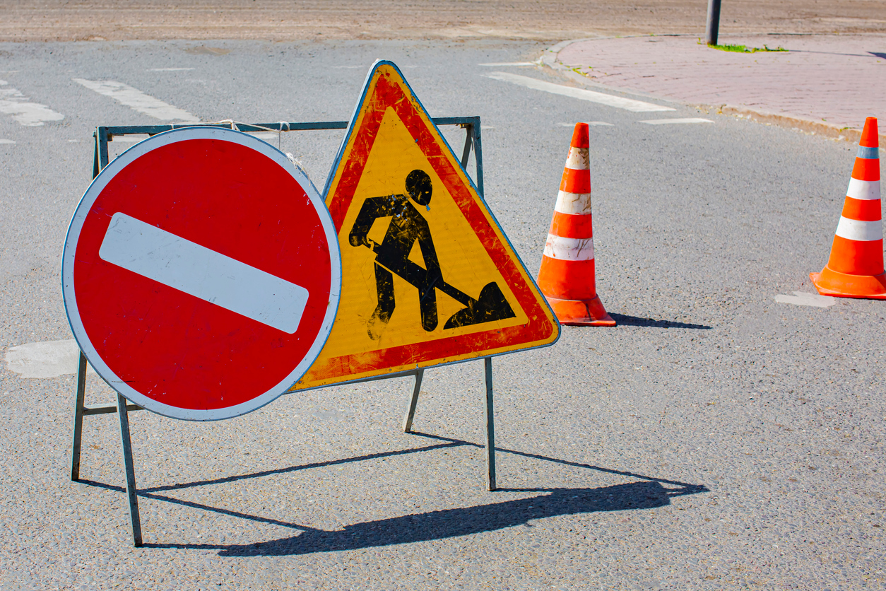 Road construction stop and triangle signs on asphalt