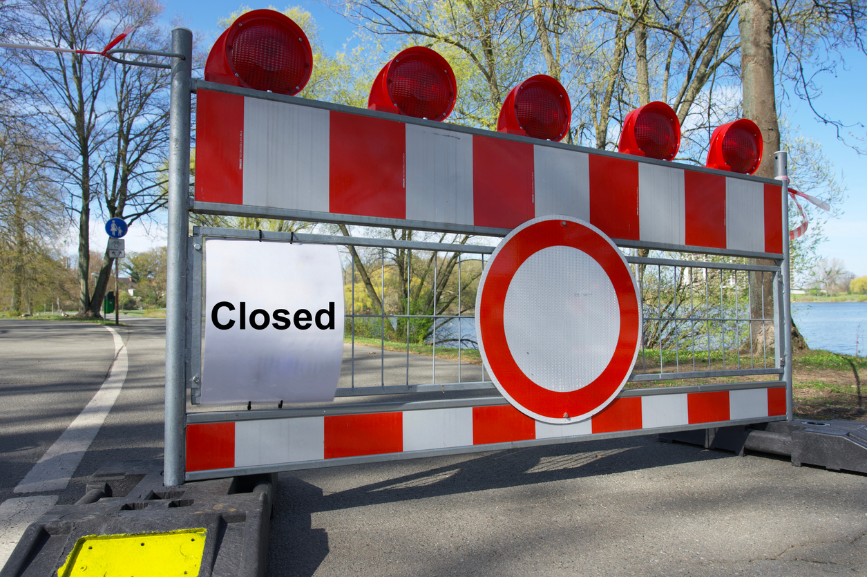 Prohibition sign and red and white barrier tape and roadblock