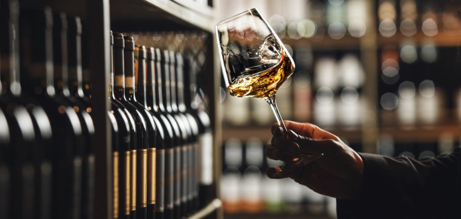 Close-Up of Sommelier Tasting White Wine in Dimly Lit Cellar Close-Up of Sommelier Tasting White Wine in Dimly Lit Cellar