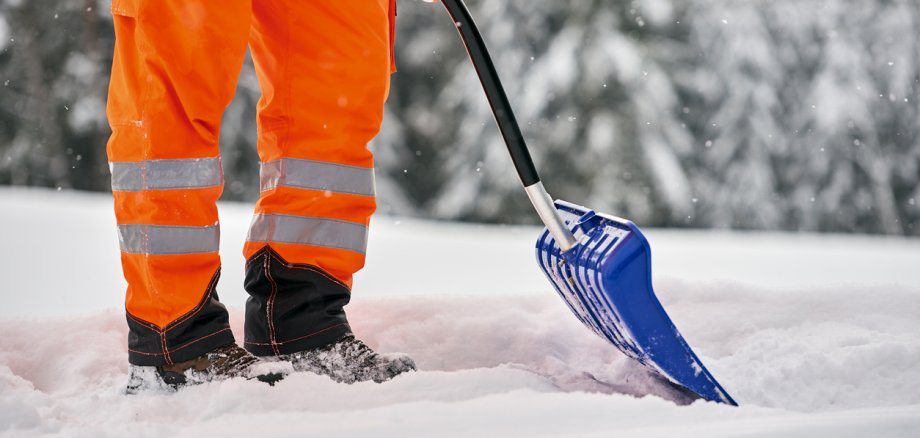 Snow removal, worker sweeps snow from road after winter storm